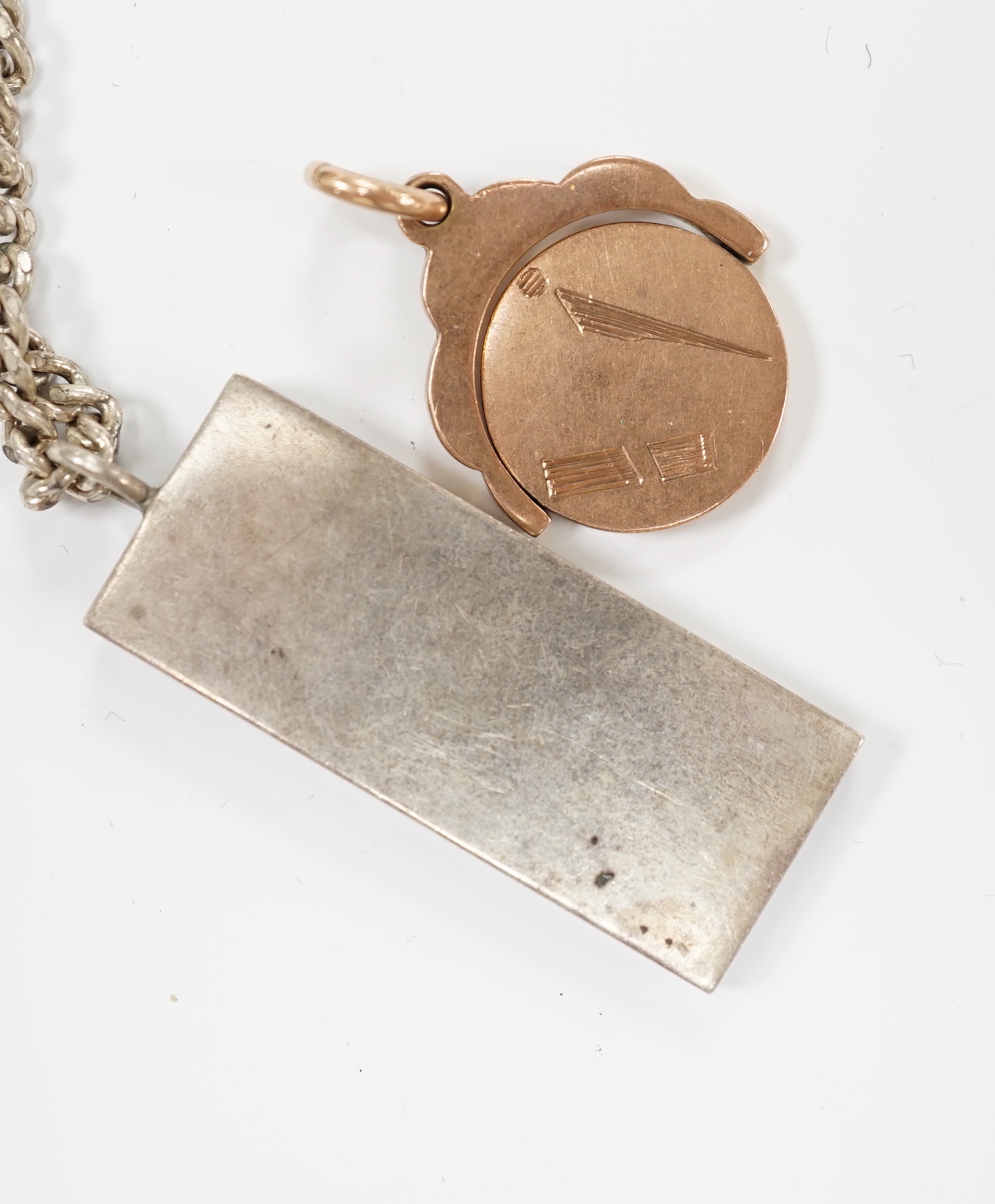 A 9ct gold swivelling masonic pendant, 12.3 grams and a silver ingot pendant, on a 925 chain.